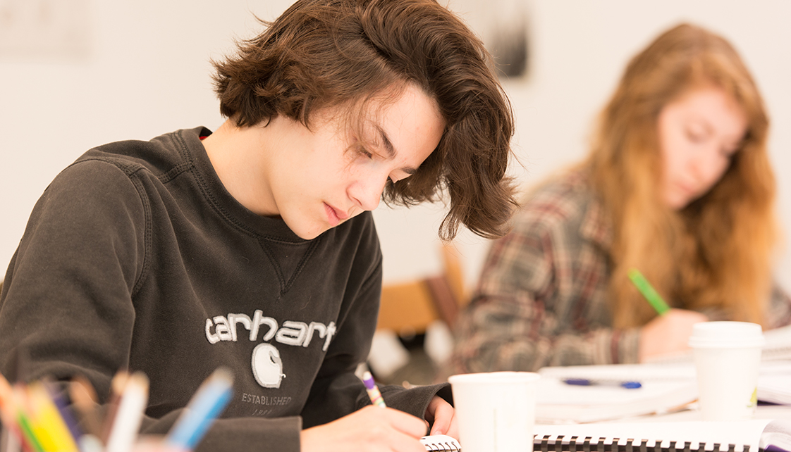 female in black sweatshirt writing