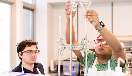 Two students cooperating on a chemistry experiment.