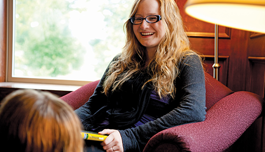 Student in lounge with Spanish book.