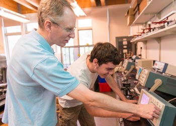 Faculty with a student with lab equipment