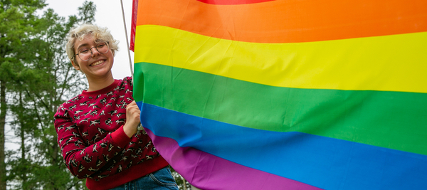 student with pride flag