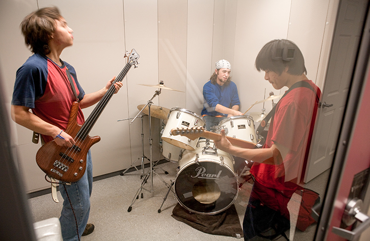 Boys at band practice in a sound-proof booth. 