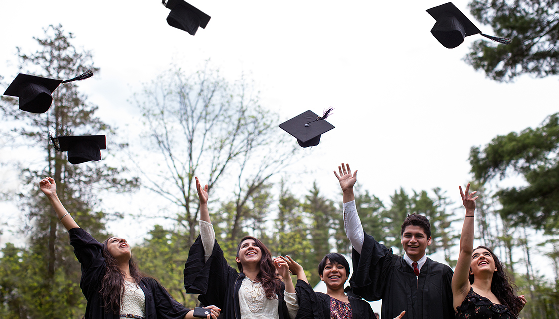 Graduating students throw their caps